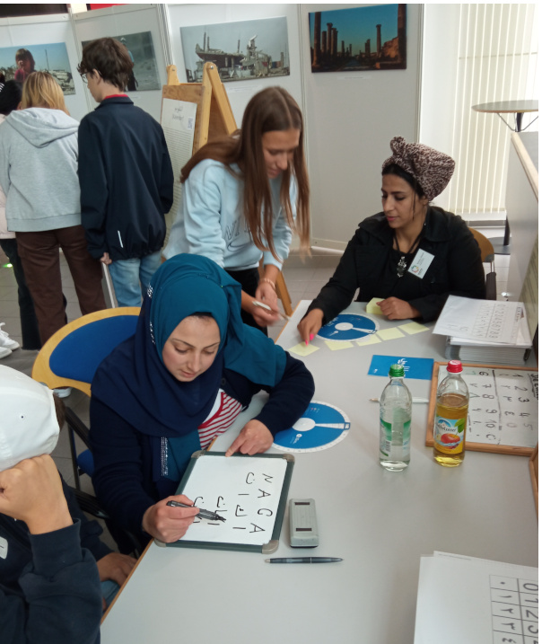 Menschen mit Fluchterfahrung begleiten unsere Schülerinnen und Schüler durch die interaktive Ausstellung Land der Kulturen